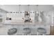 Bright white kitchen with stainless steel appliances, ample counter space, and gray bar stools at 10500 Sherman St, Englewood, FL 34224