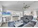 Open-concept living room with a large TV, gray sofa, and view of the dining area and kitchen at 10500 Sherman St, Englewood, FL 34224