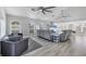 Bright, airy living room with modern gray furniture, ceiling fans, light floors and many windows at 10500 Sherman St, Englewood, FL 34224
