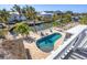 A stunning aerial view of the private pool, tiki bar, and canal front in this luxury tropical home at 10500 Sherman St, Englewood, FL 34224