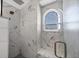 Modern shower featuring rain shower head, marble tile, and a convenient corner seat at 10500 Sherman St, Englewood, FL 34224