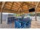 Poolside tiki hut features a kitchen prep area, TV, ceiling fan, and seating at 10500 Sherman St, Englewood, FL 34224