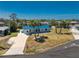Aerial view of a single-story home with a blue roof, palm trees, and a long concrete driveway at 1167 Delmar St, Englewood, FL 34224