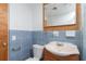 Bathroom showing the toilet, vanity with wood cabinets, mirror, and blue tiling at 1167 Delmar St, Englewood, FL 34224