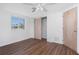 This bedroom includes hardwood floors, white walls, a window, and closet space at 1167 Delmar St, Englewood, FL 34224