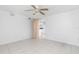 Neutral bedroom with white tile flooring, a ceiling fan, and a door leading to the kitchen at 1167 Delmar St, Englewood, FL 34224