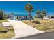 Beautiful single-story home with a blue metal roof, a concrete driveway, and lush green lawn at 1167 Delmar St, Englewood, FL 34224