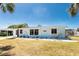 Inviting single-story home with a blue roof, well-manicured lawn, and bright natural light at 1167 Delmar St, Englewood, FL 34224