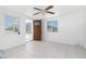 Bright living room with neutral-toned tile floors, ceiling fan, and natural light from two windows at 1167 Delmar St, Englewood, FL 34224