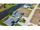 Aerial view of waterfront home featuring a canal view, well-manicured lawn, and paved driveway at 1167 Rotonda Cir, Rotonda West, FL 33947
