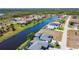 This aerial view showcases a waterfront home with a private pool and expansive green space at 1167 Rotonda Cir, Rotonda West, FL 33947