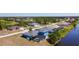 Aerial view of a home with a screened pool in a golf community with access to a canal at 1167 Rotonda Cir, Rotonda West, FL 33947