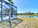View of backyard, pool, and screened-in lanai with a canal in the background at 1167 Rotonda Cir, Rotonda West, FL 33947
