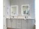 Well lit double vanity sink with decorative wallpaper and mirrors at 1167 Rotonda Cir, Rotonda West, FL 33947