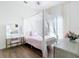 Bedroom featuring a four poster canopy bed, wood floors, and ample sunlight at 1167 Rotonda Cir, Rotonda West, FL 33947