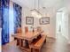 Dining room with chandelier and wooden table with bench seating and blue accent curtains at 1167 Rotonda Cir, Rotonda West, FL 33947