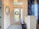 Foyer with tile floors, front door with glass, chandelier, oval mirror, and blue accent curtains at 1167 Rotonda Cir, Rotonda West, FL 33947