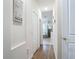 Bright hallway with wood floors leads to bathroom with garden tub and glass enclosed shower at 1167 Rotonda Cir, Rotonda West, FL 33947