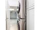 Modern laundry area with stacked washer/dryer, white cabinetry and access to the garage at 1167 Rotonda Cir, Rotonda West, FL 33947