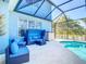 Relaxing outdoor pool area with blue patio furniture and enclosed lanai at 1167 Rotonda Cir, Rotonda West, FL 33947