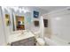 Bright bathroom features a shower-tub combo, white vanity, and a decorative mirror at 11750 Tempest Harbor Loop, Venice, FL 34292