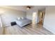 Bedroom featuring wood floors, ceiling fan, and view into bathroom at 11750 Tempest Harbor Loop, Venice, FL 34292