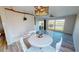 Bright dining room with modern light fixture, ceiling fan, and scenic pond views at 11750 Tempest Harbor Loop, Venice, FL 34292