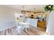 Charming kitchen with white table and chairs, stainless steel appliances, and wood flooring at 11750 Tempest Harbor Loop, Venice, FL 34292