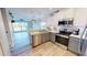 Open concept kitchen features stainless steel appliances and light wood flooring with water views at 11750 Tempest Harbor Loop, Venice, FL 34292