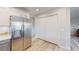 Spacious kitchen with stainless steel refrigerator, white cabinets, and wood flooring at 11750 Tempest Harbor Loop, Venice, FL 34292