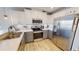 Bright kitchen with white cabinets, stainless steel appliances, and wood flooring at 11750 Tempest Harbor Loop, Venice, FL 34292