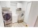 Well-lit laundry room with front-loading washer and dryer, and ample cabinet space at 11750 Tempest Harbor Loop, Venice, FL 34292