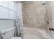 Shower and tub with neutral marble-look tiling, complementing fixtures, and bright natural light at 13100 S Mccall Rd # 112, Port Charlotte, FL 33981