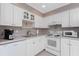 Bright kitchen featuring ample white cabinetry, modern appliances and tile backsplash at 13100 S Mccall Rd # 112, Port Charlotte, FL 33981