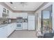 Cozy kitchen with white cabinetry and appliances, tiled floor, and sliding doors to the outside at 13100 S Mccall Rd # 112, Port Charlotte, FL 33981