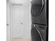 Modern laundry area featuring stacked washer and dryer, next to a door at 13100 S Mccall Rd # 112, Port Charlotte, FL 33981
