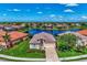Aerial view of a beautiful single-story house near a lake and surrounded by lush landscaping in a residential community at 13335 Golf Pointe Dr, Port Charlotte, FL 33953