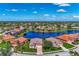 Expansive aerial view of a luxury community with homes surrounding a scenic lake and lush landscaping on a sunny day at 13335 Golf Pointe Dr, Port Charlotte, FL 33953