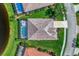 Aerial view of the home showcases the screened-in pool and lush landscaping at 13335 Golf Pointe Dr, Port Charlotte, FL 33953