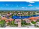 Expansive aerial view of a luxury community with homes surrounding a scenic lake and lush landscaping on a sunny day at 13335 Golf Pointe Dr, Port Charlotte, FL 33953