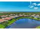 Community aerial view showcases many homes surrounding a large lake and preserve at 13335 Golf Pointe Dr, Port Charlotte, FL 33953