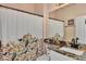 Charming bathroom featuring a granite countertop vanity and decorative shower curtain at 13335 Golf Pointe Dr, Port Charlotte, FL 33953