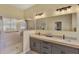Bright bathroom with a double sink vanity, a glass-enclosed shower, and modern lighting at 13335 Golf Pointe Dr, Port Charlotte, FL 33953