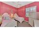 Bright bedroom with two twin beds, stylish decor, and a large window at 13335 Golf Pointe Dr, Port Charlotte, FL 33953