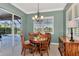 The dining area features backyard views, a wooden table set, a hanging chandelier, and natural light at 13335 Golf Pointe Dr, Port Charlotte, FL 33953
