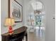 Inviting entryway with tile flooring, elegant lighting, a decorative table, and a view of the front door at 13335 Golf Pointe Dr, Port Charlotte, FL 33953