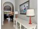 Hallway featuring neutral walls, arched doorways, decor, and tile flooring leading to a view of the backyard at 13335 Golf Pointe Dr, Port Charlotte, FL 33953