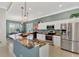 Bright kitchen featuring granite countertops, stainless steel appliances, an island with a sink, and modern lighting at 13335 Golf Pointe Dr, Port Charlotte, FL 33953