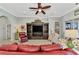 Inviting living room with tile flooring, a ceiling fan, comfortable seating, and a view of the hallway at 13335 Golf Pointe Dr, Port Charlotte, FL 33953