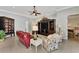 Well-decorated living room featuring tile flooring, a ceiling fan, comfortable seating, and a view of the hallway at 13335 Golf Pointe Dr, Port Charlotte, FL 33953